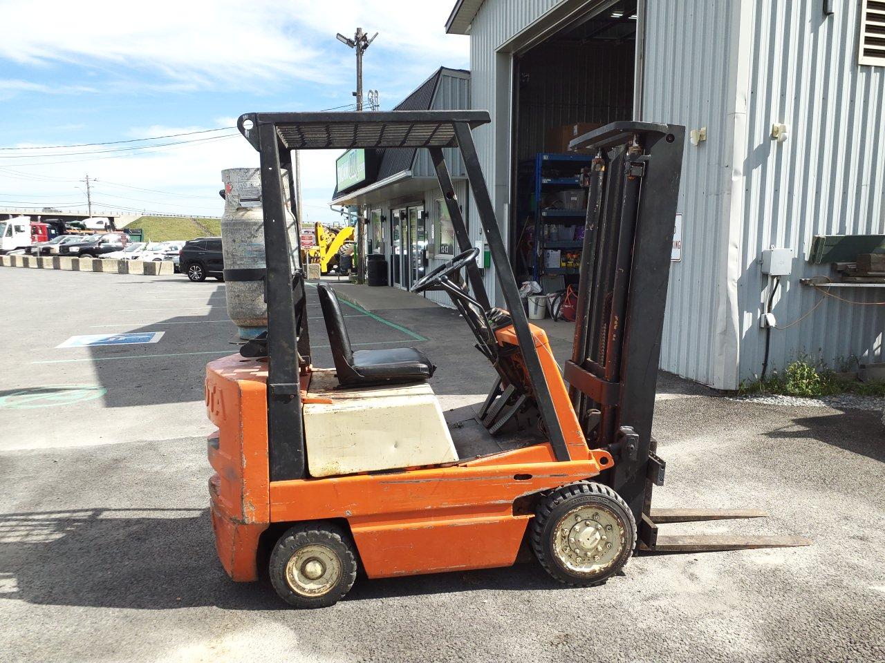 A 40-3FGC15 Toyota forklift parked outside a workshop in broad daylight